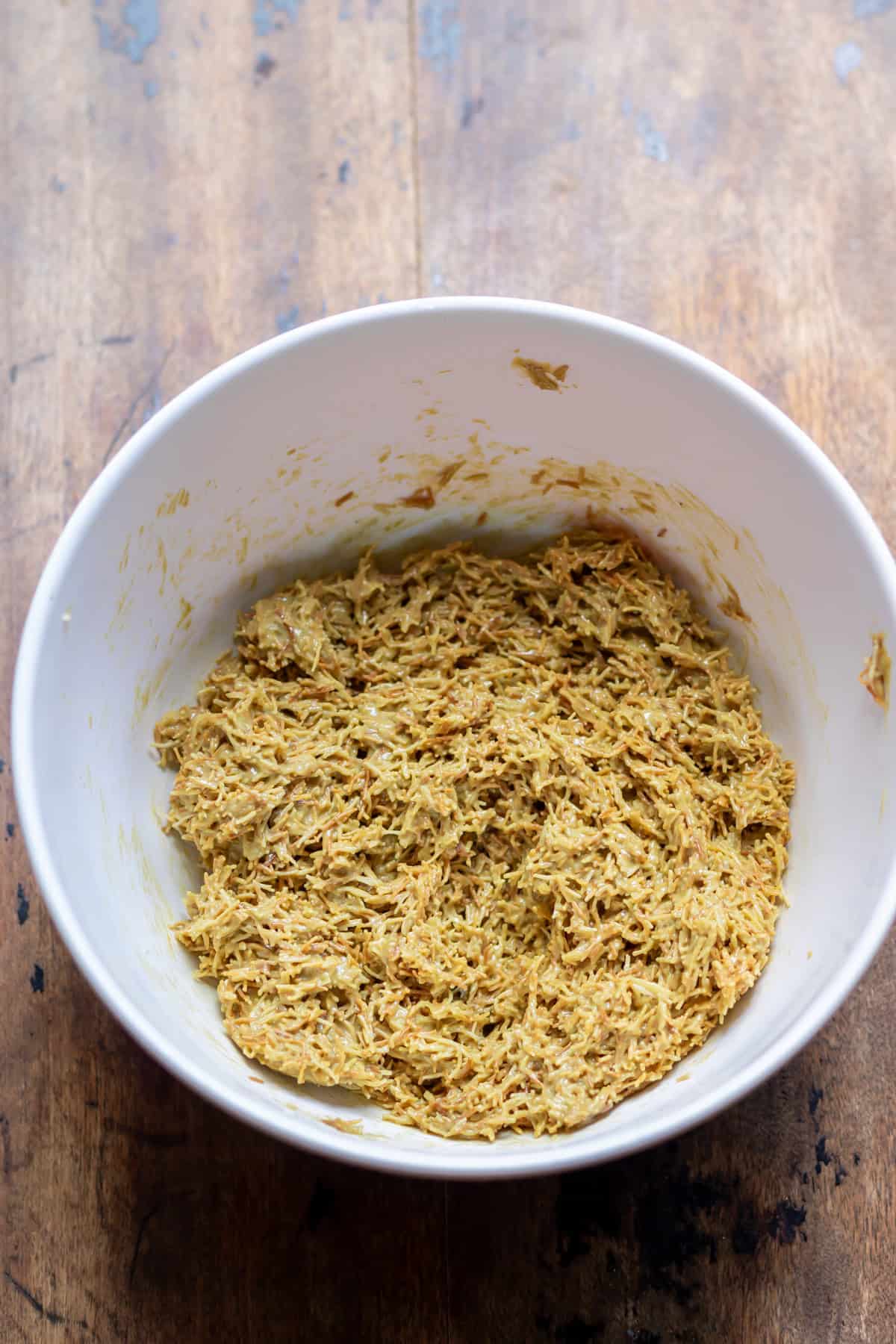 Stirring the kadayif into the pistachio tahini mixture.