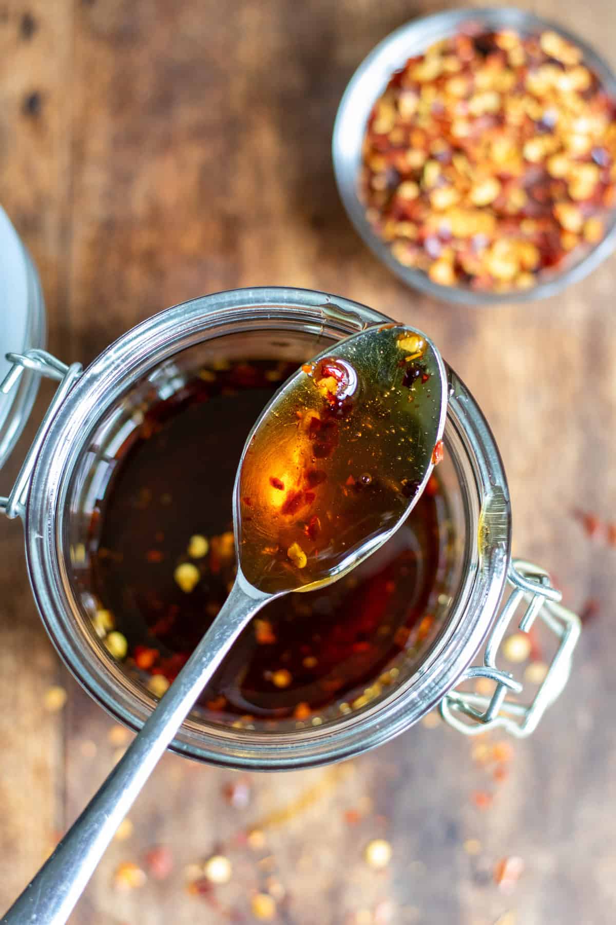 Looking down at a spoon in a jar of hot maple syrup.