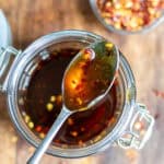 Looking down at a spoon in a jar of hot maple syrup.