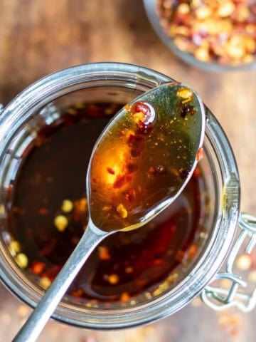 Looking down at a spoon in a jar of hot maple syrup.