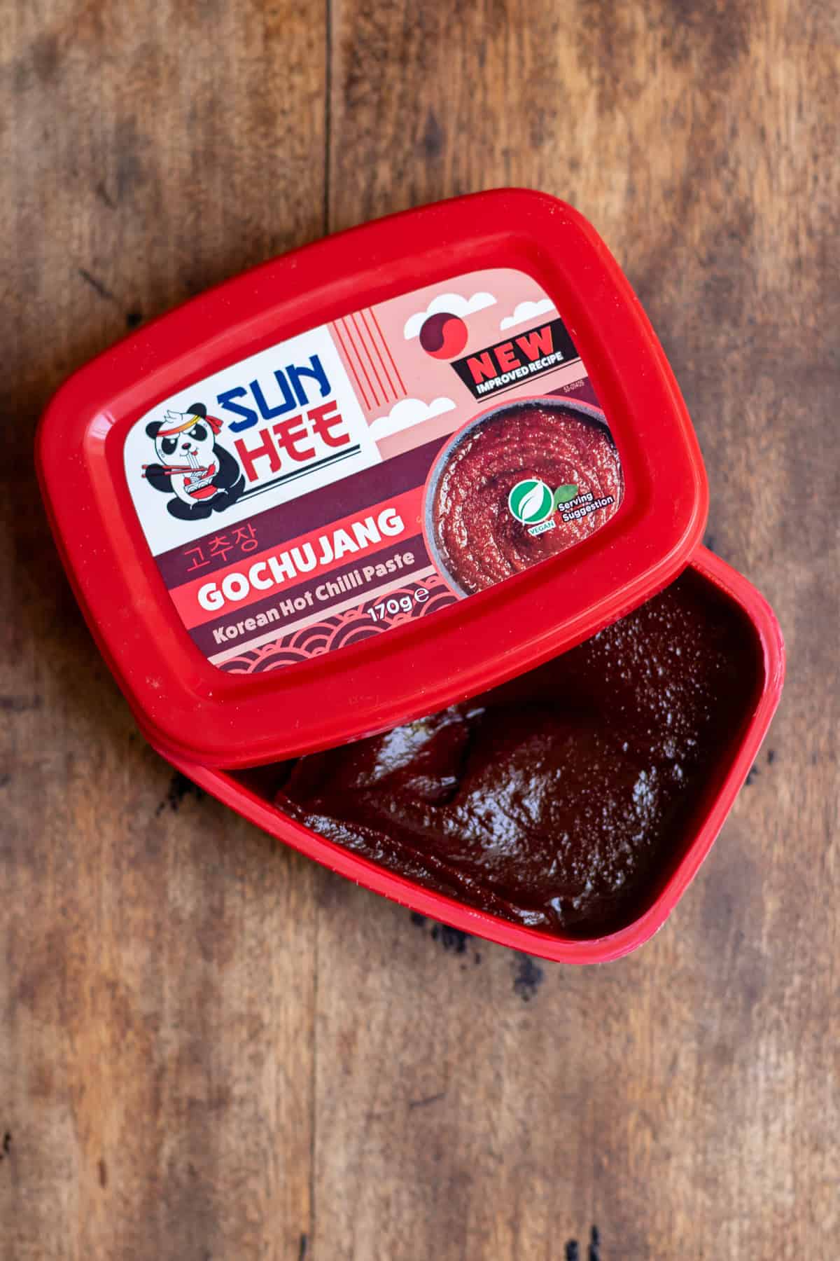 A tub of gochujang paste on a table.