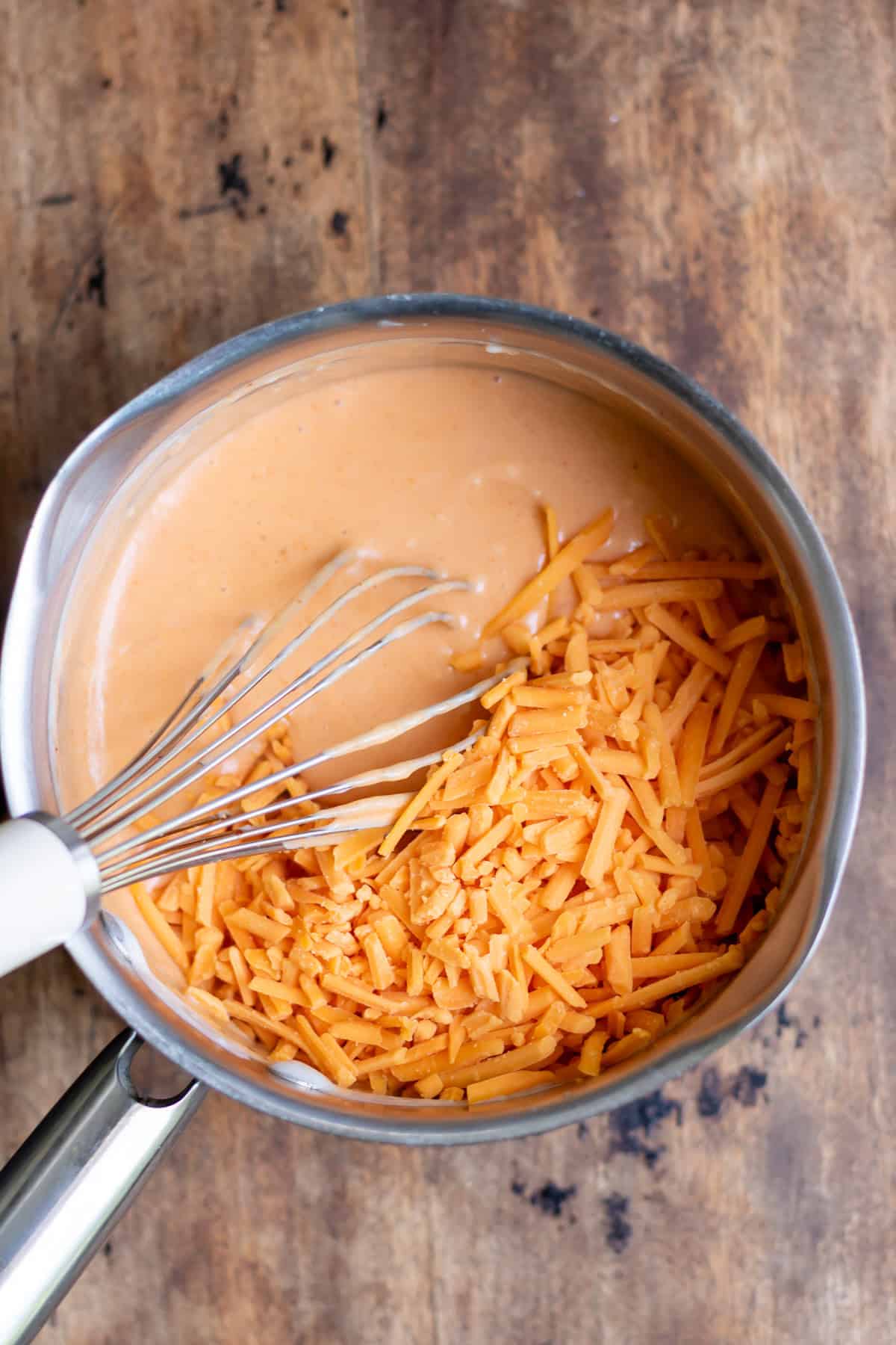 Stirring the grated cheese into the gochujang sauce.