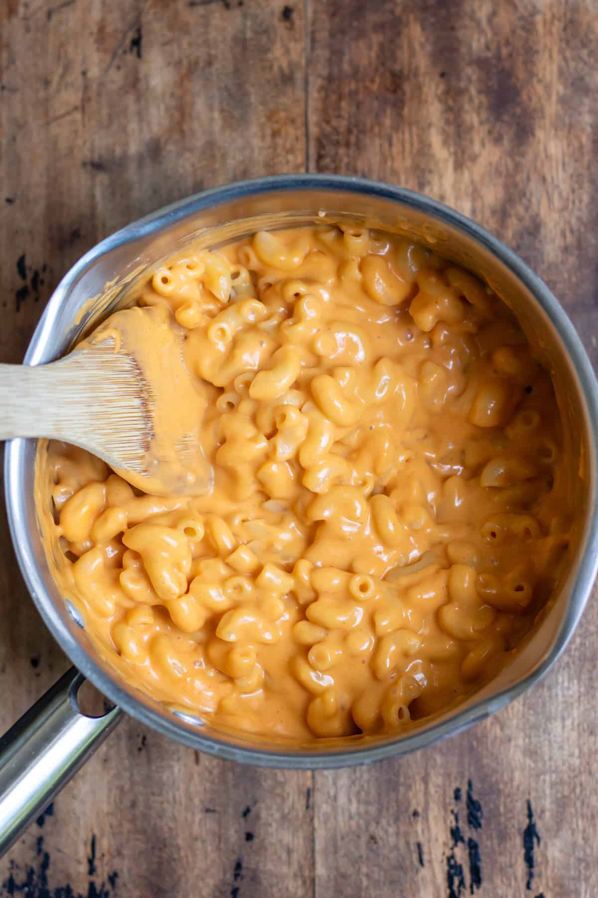Mixing the pasta into the gochujang cheese sauce.