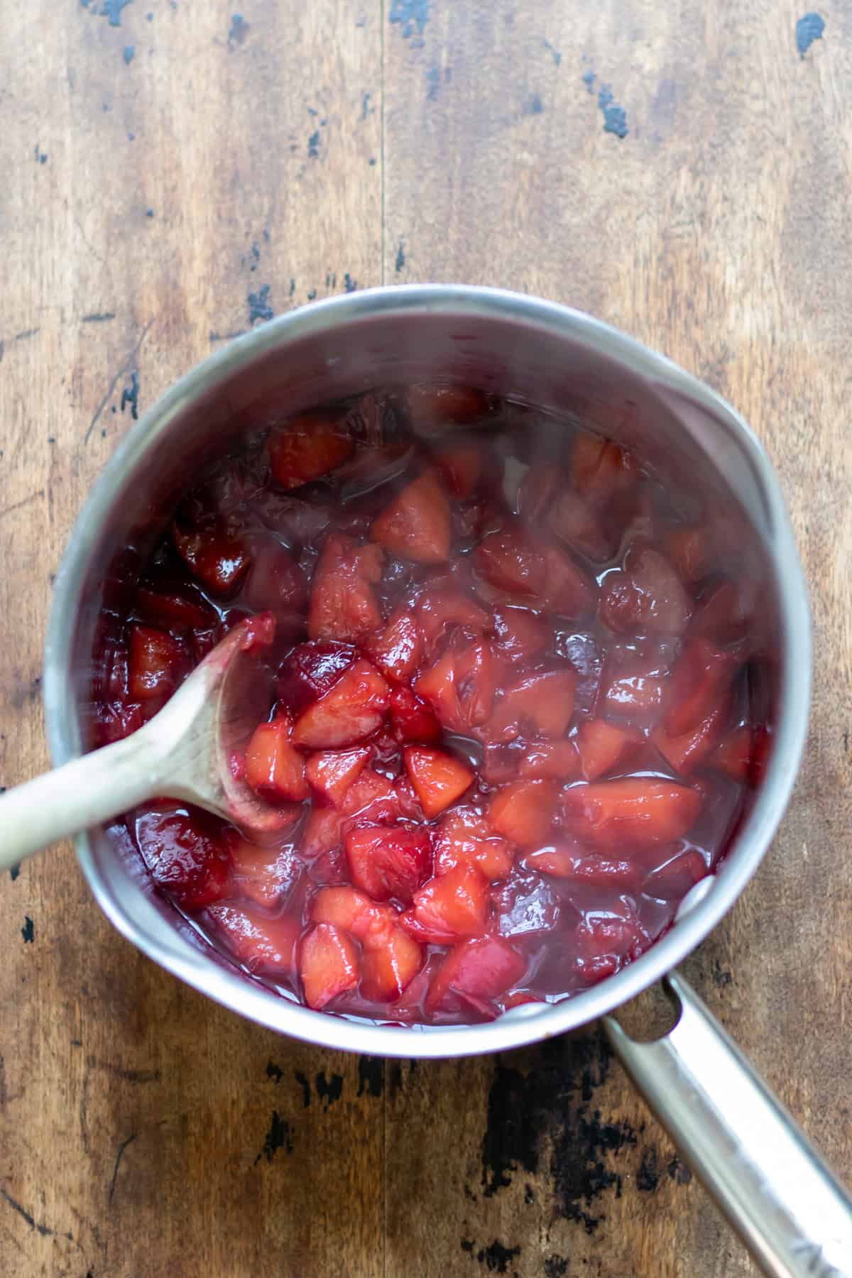 Cooking the plum compote in a saucepan.