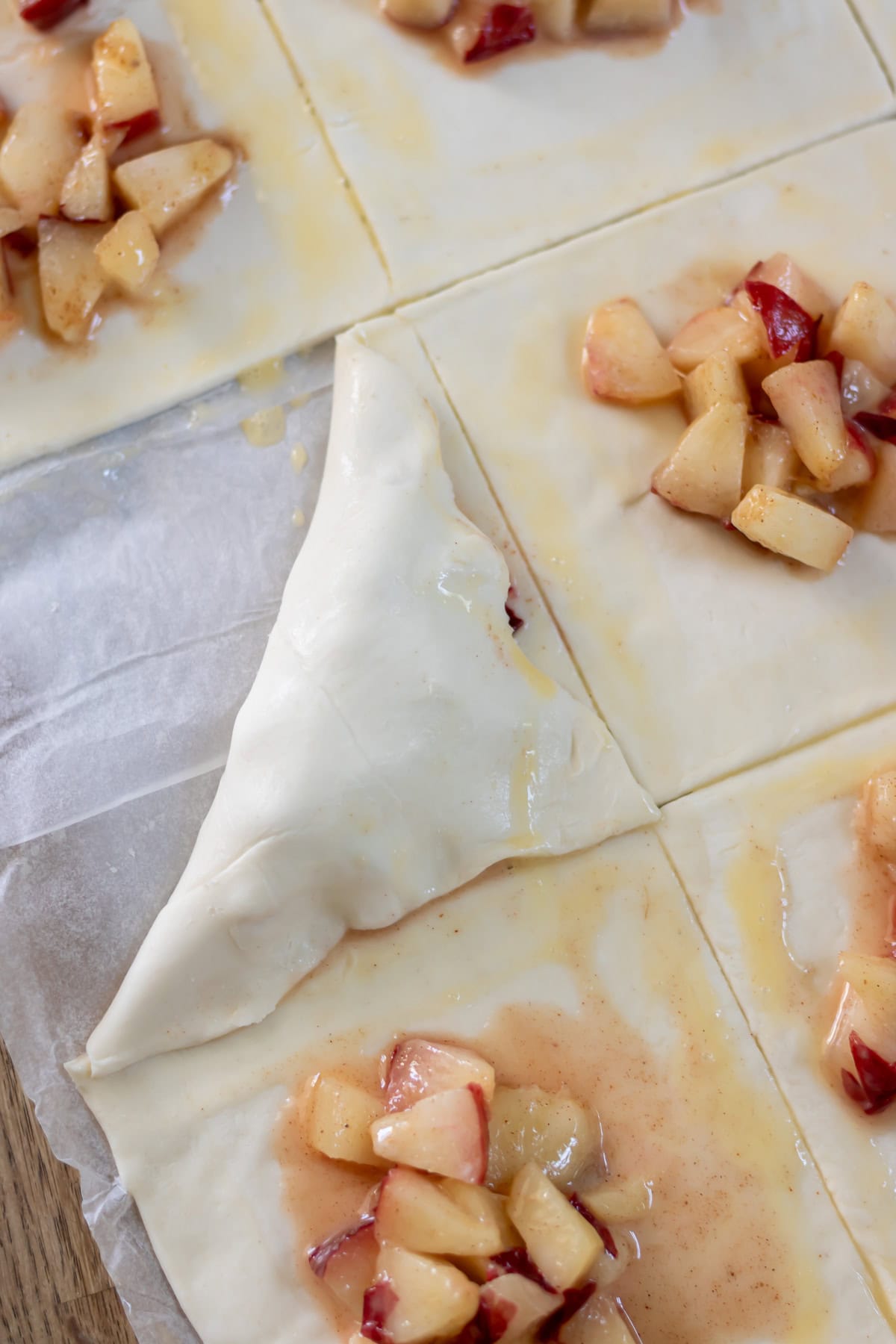 Folding the pastry over the nectarines to form a triangle.