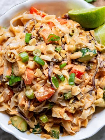 Looking down at a serving dish of peanut rice noodle salad on a table.