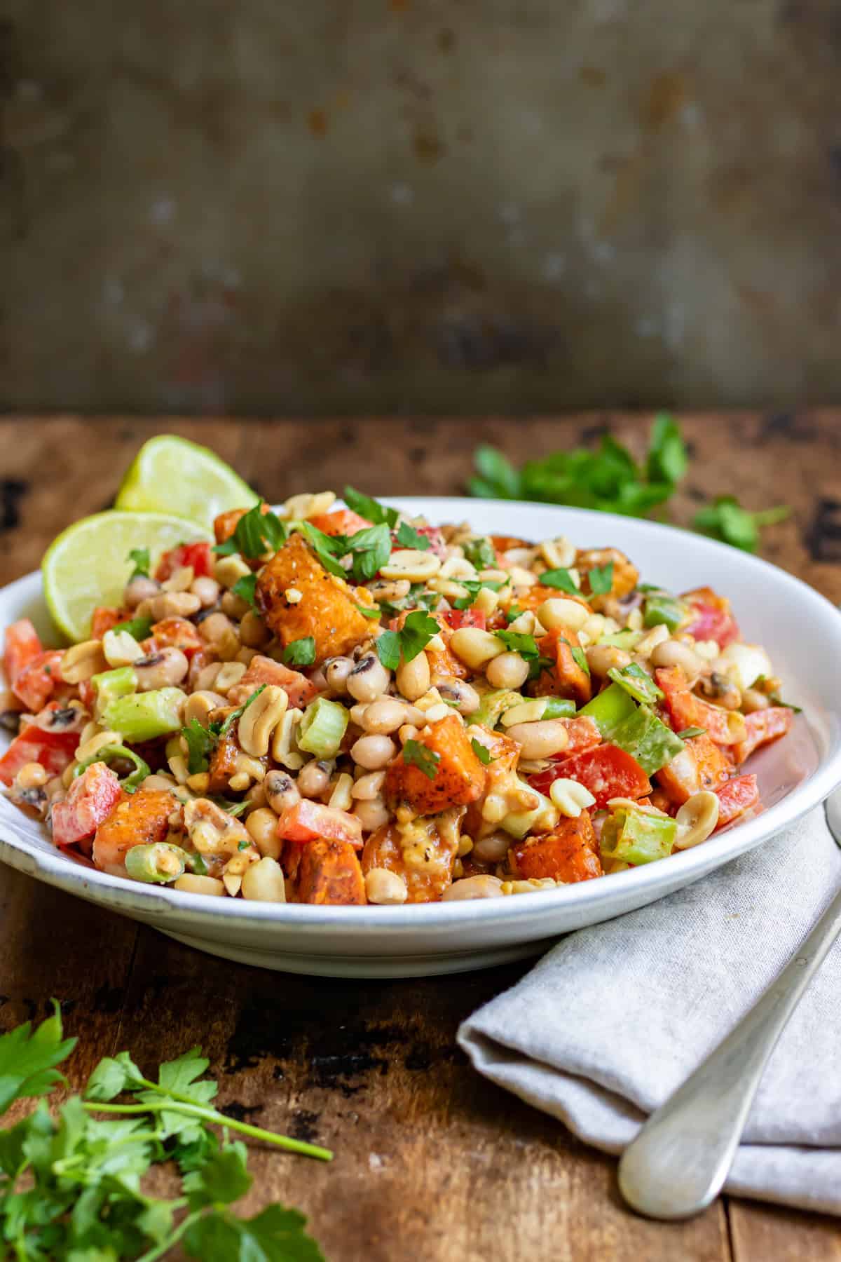 Side view of a table with a bowl of vegetable bean salad.