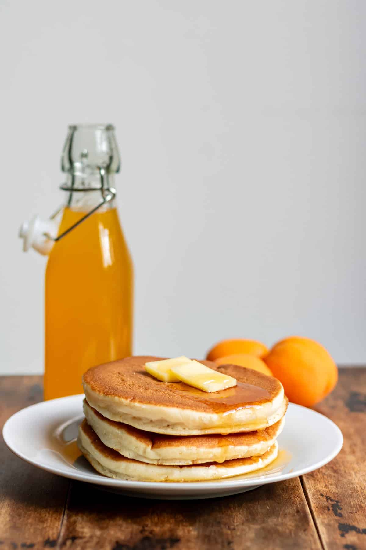Stack of pancakes with apricot syrup.