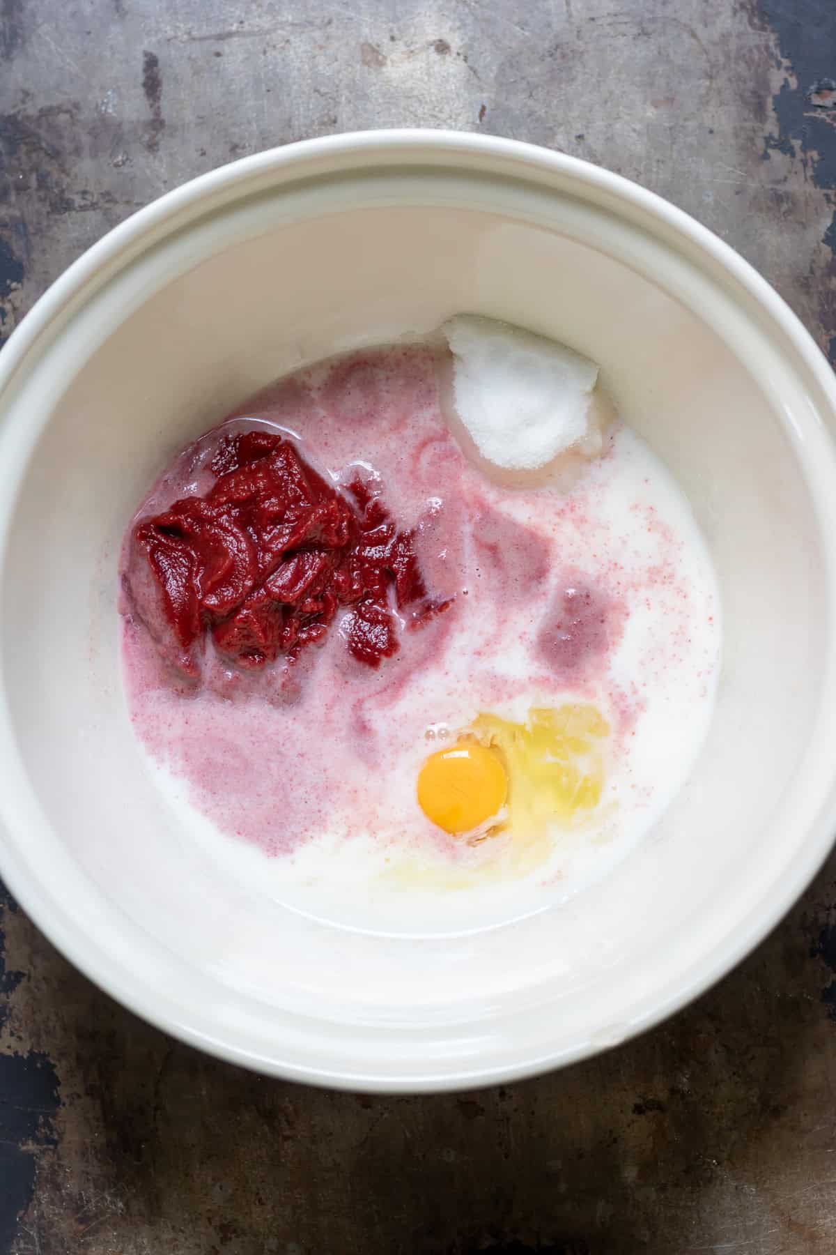 Pureed beets, milk, sugar and eggs in a mixing bowl.