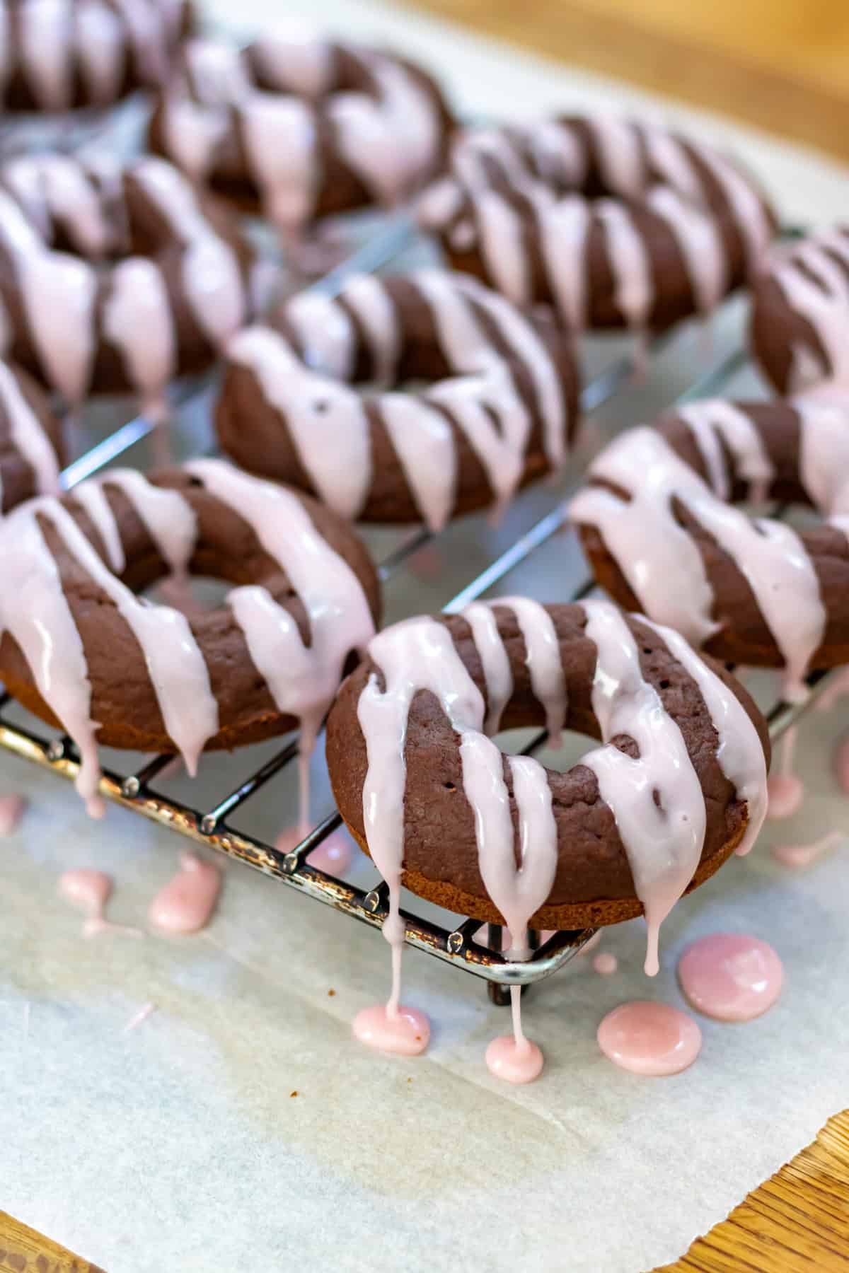Drizzling the beet glaze over the beetroot chocolate donuts.