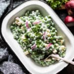 Looking down at an enamel dish with pea salad.