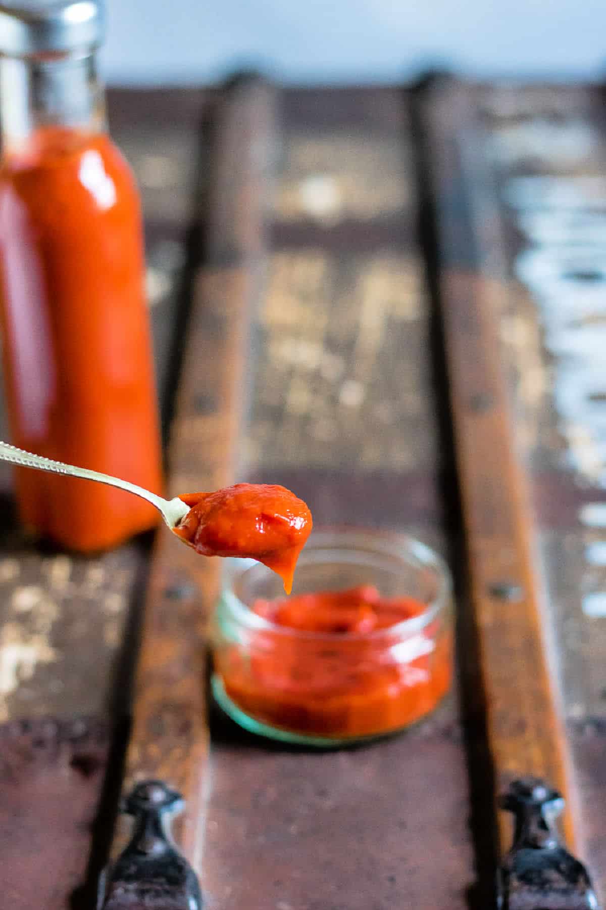 Spoon coming out of a dish of homemade tomato ketchup.