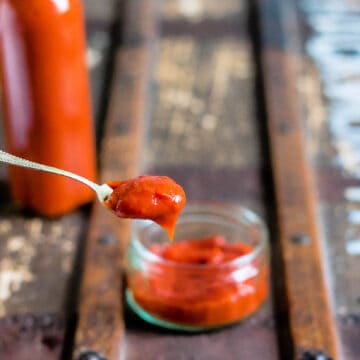 Spoon coming out of a dish of homemade tomato ketchup.