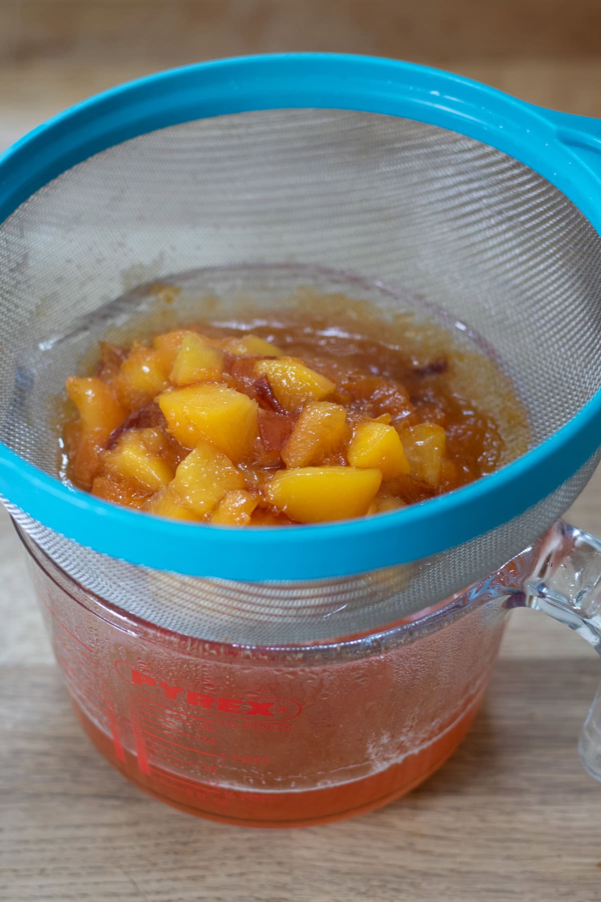 Straining the nectarines out over a jug.