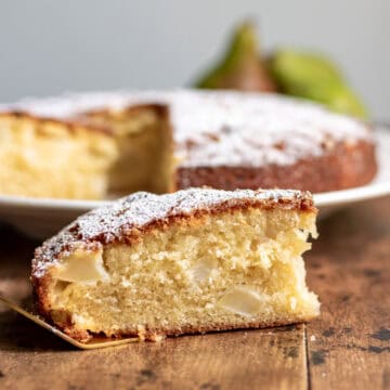 Side view of a slice of pear cake on a golden cake server.