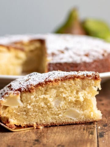 Side view of a slice of pear cake on a golden cake server.