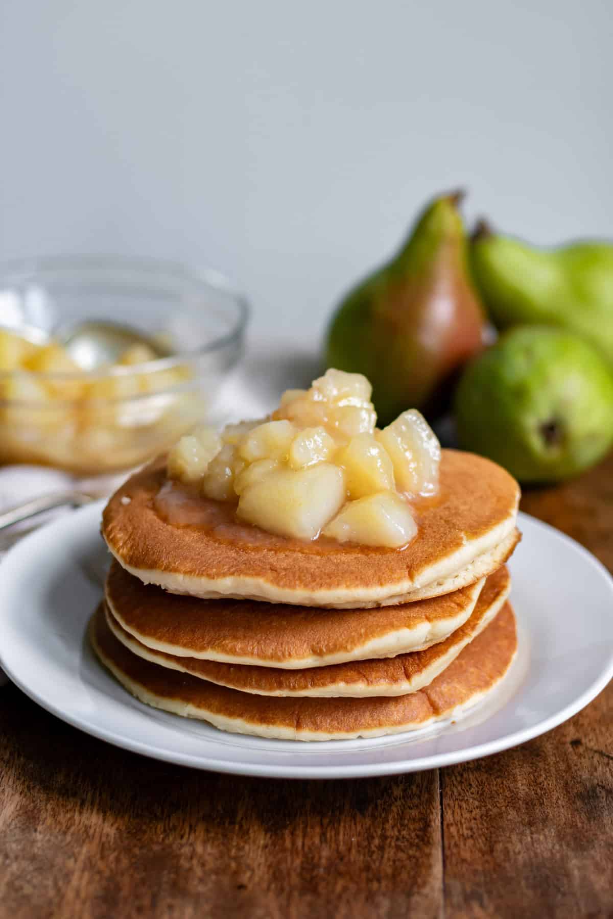 A stack of pancakes topped with pear compote.
