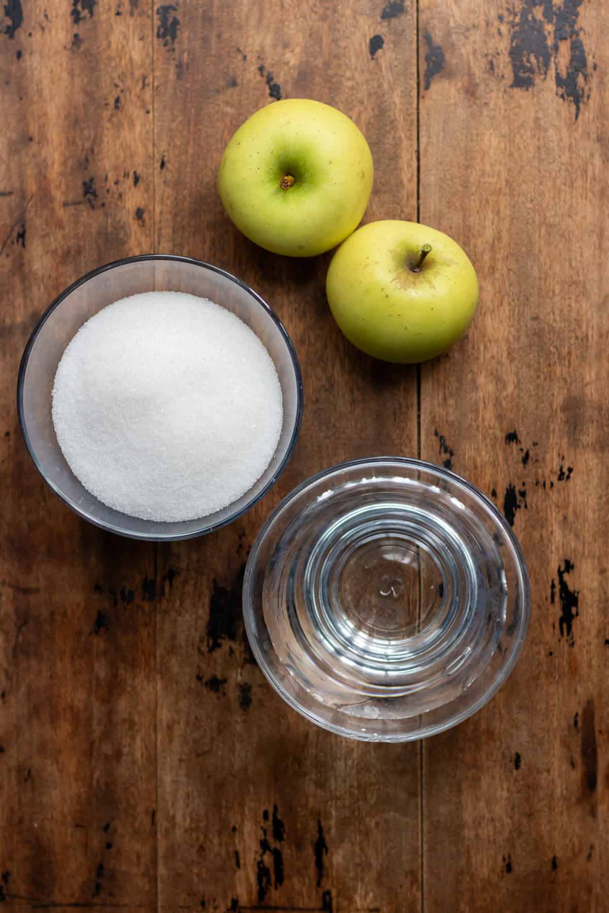 Apples, sugar and water on a table.