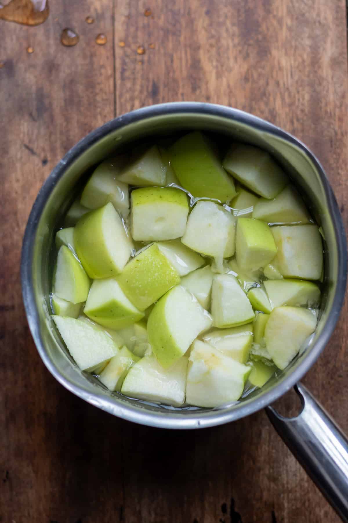 Apples, sugar and water stirred in the saucepan.