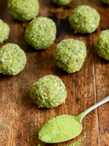 A table with matcha balls and a spoonful of matcha powder.