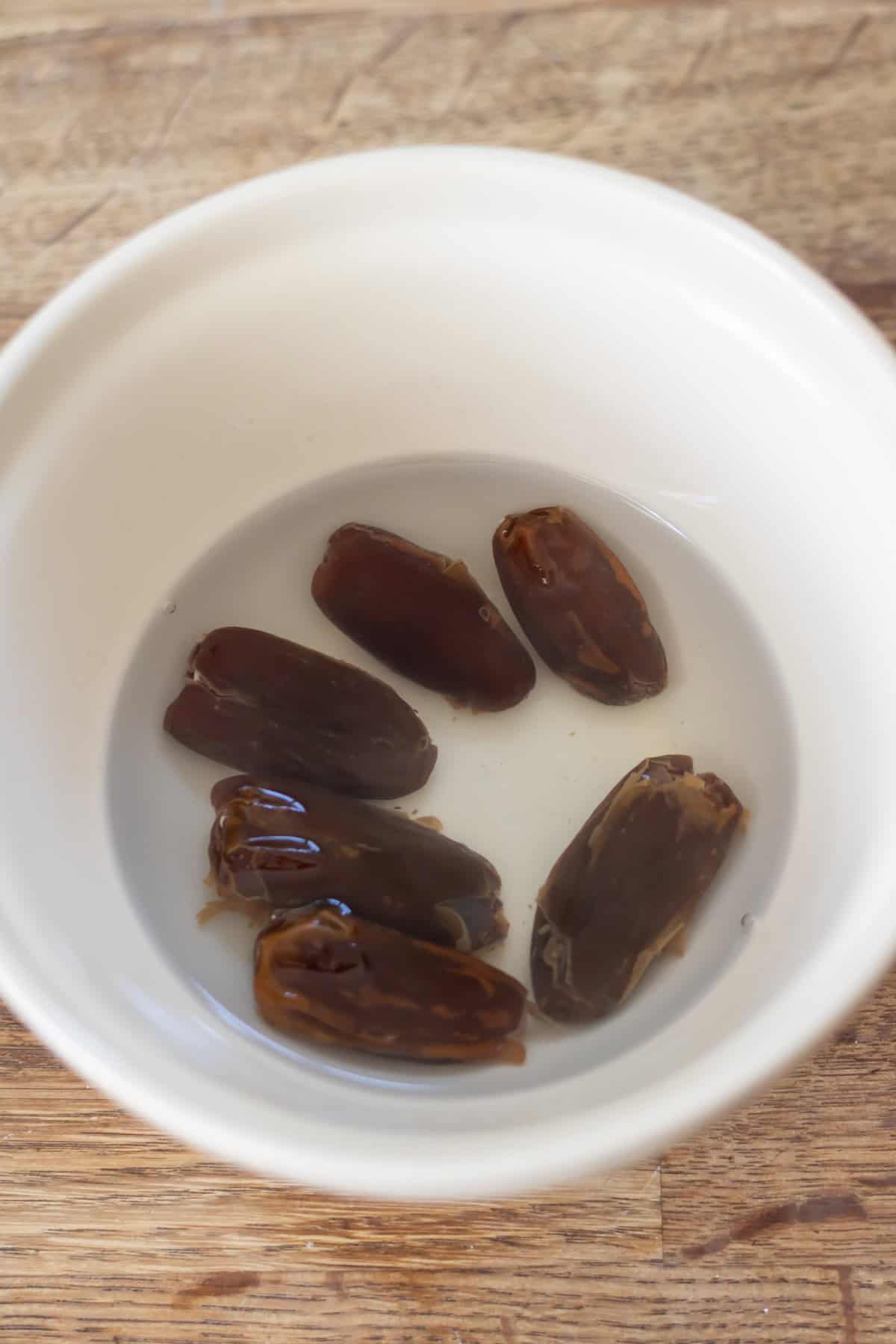 Soaking dates in warm water in a bowl.
