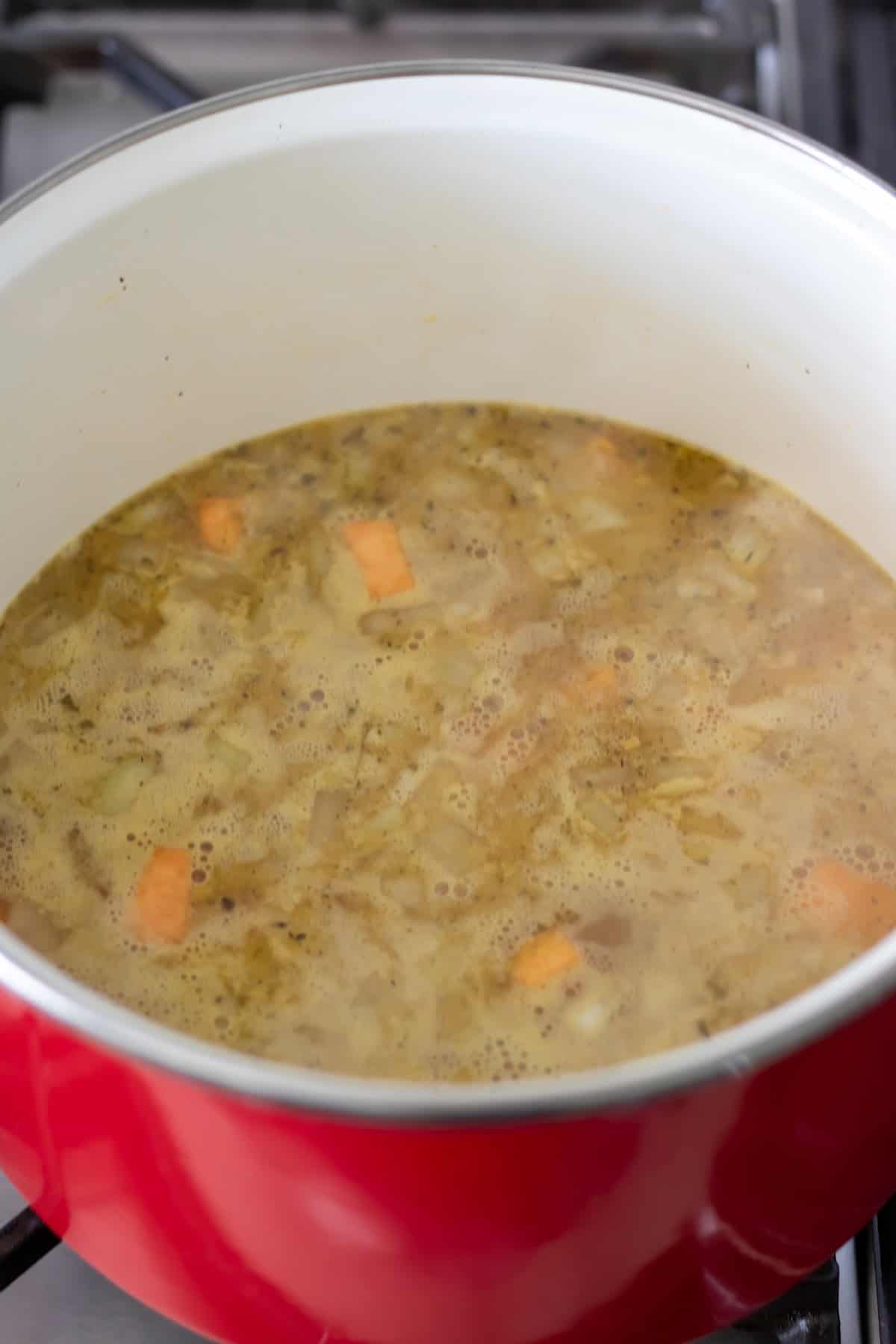 Simmering the soup in a large pot.