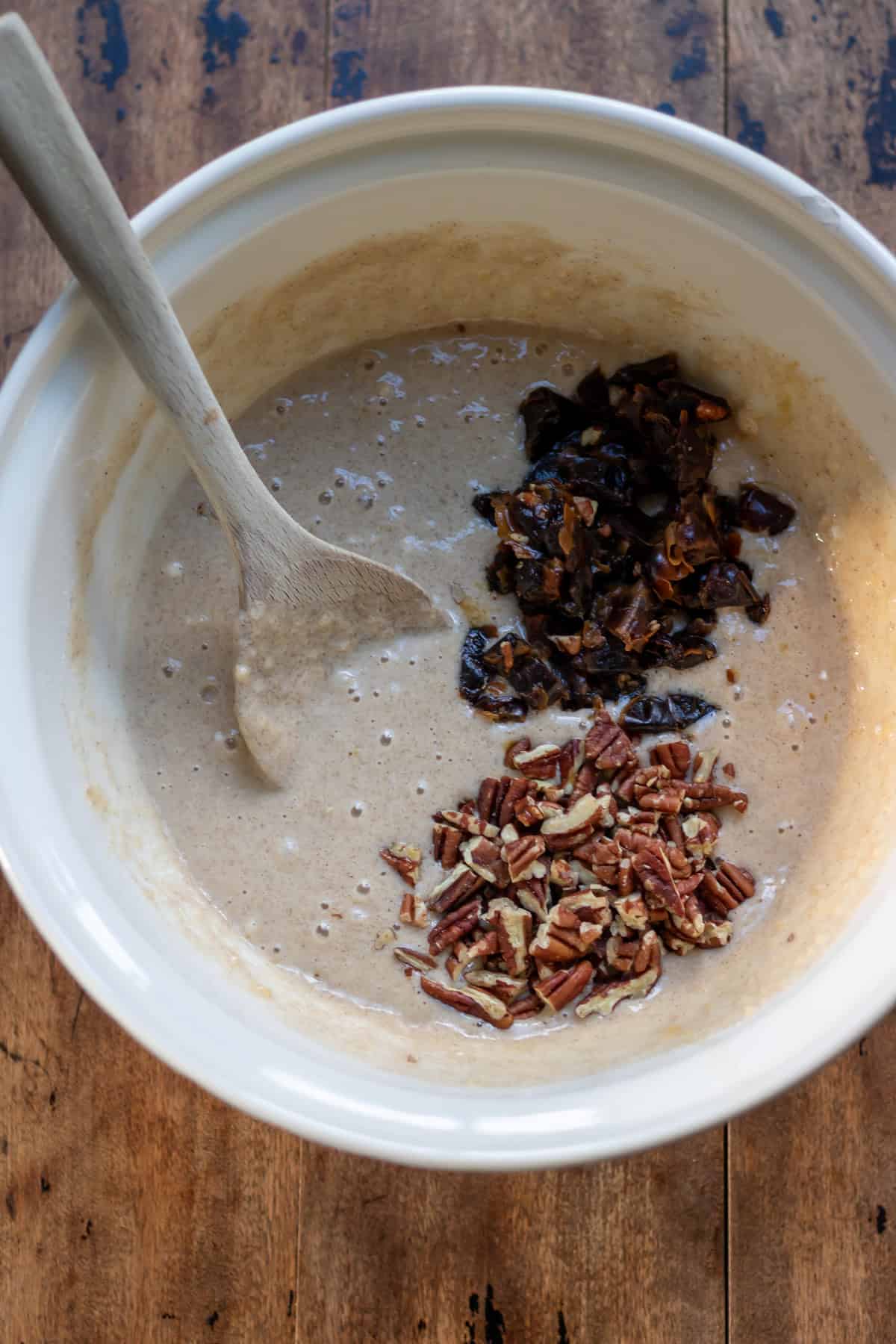Adding the chopped dates and pecans to the batter.