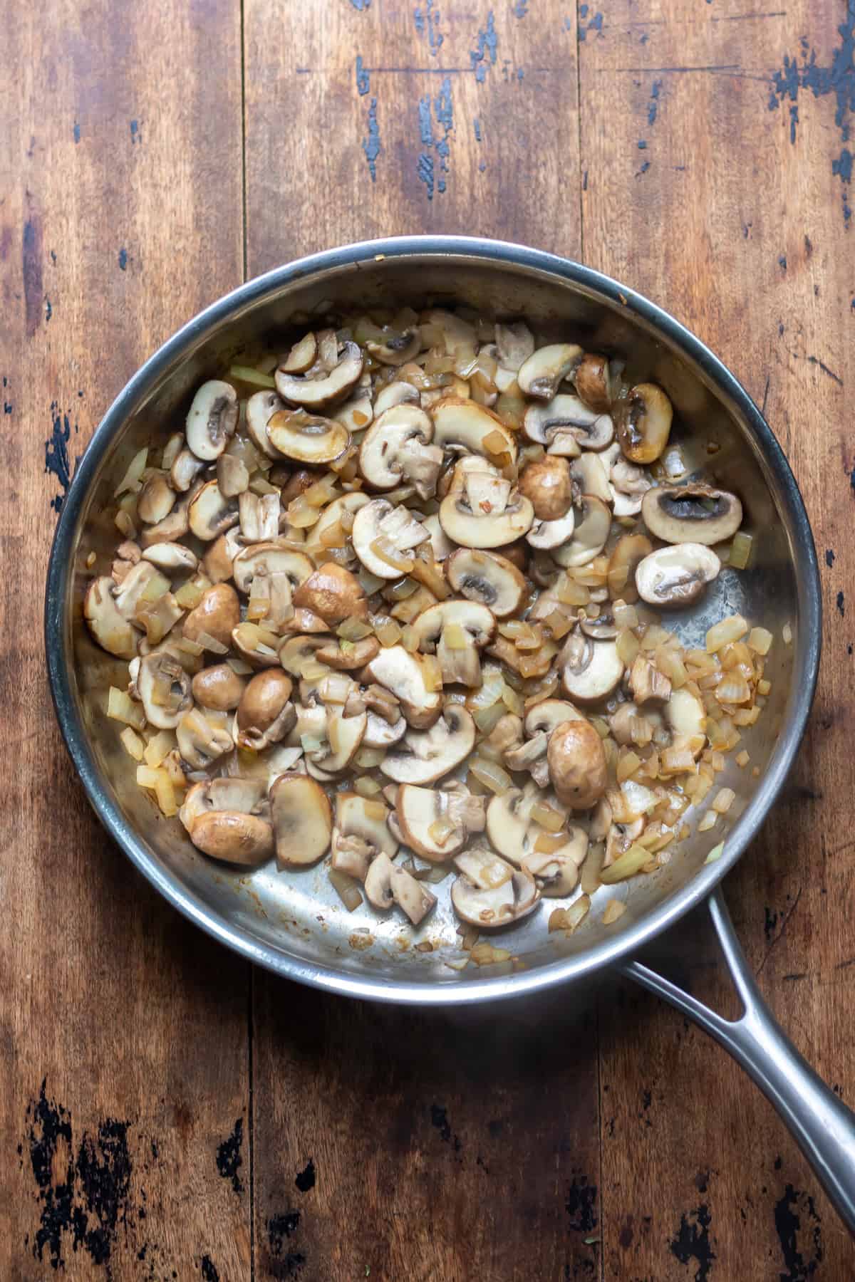 Frying pan with cooked mushrooms and onions.