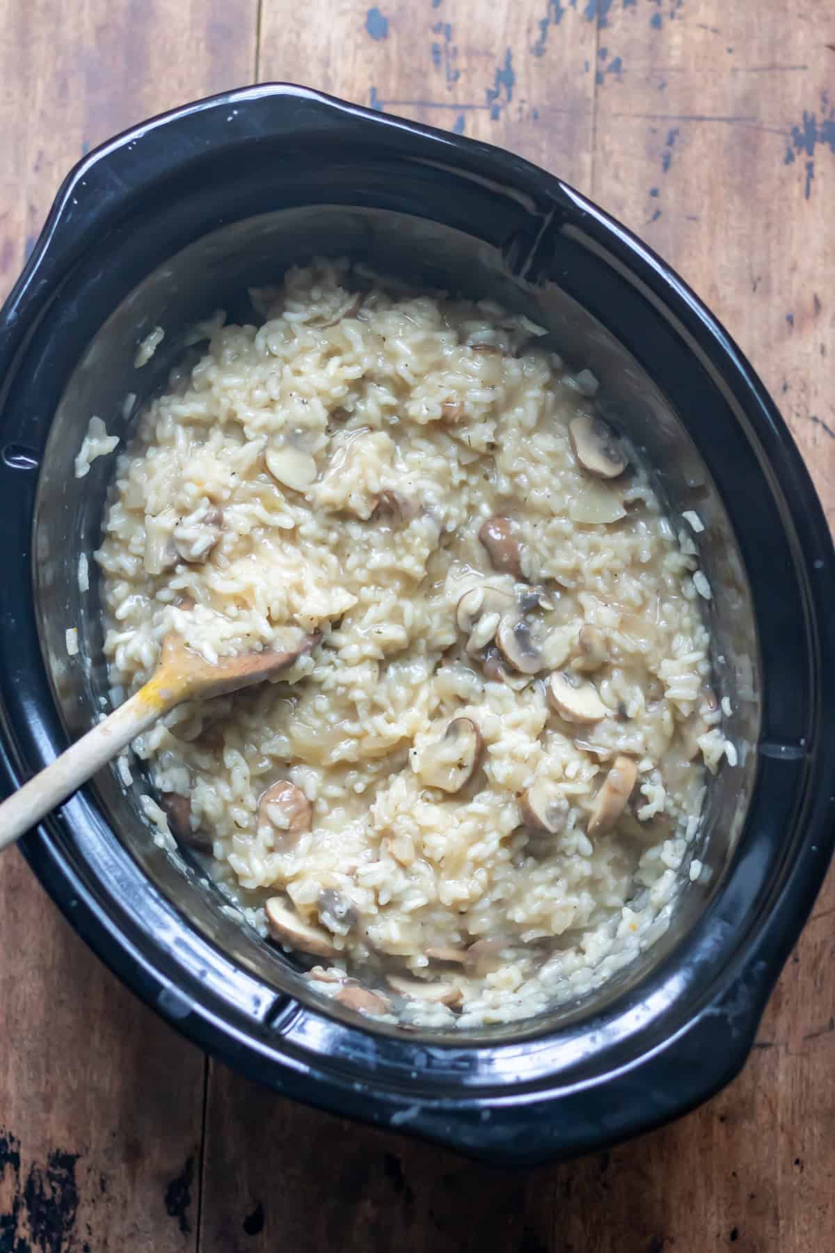 Stirring the mushroom risotto in the crockpot.