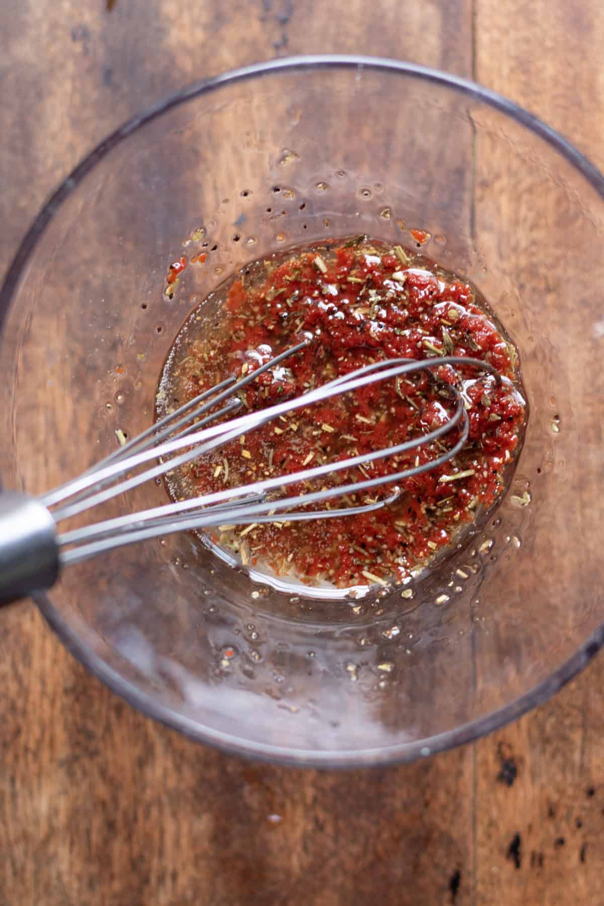Mixing the tomato paste dressing in a small bowl.