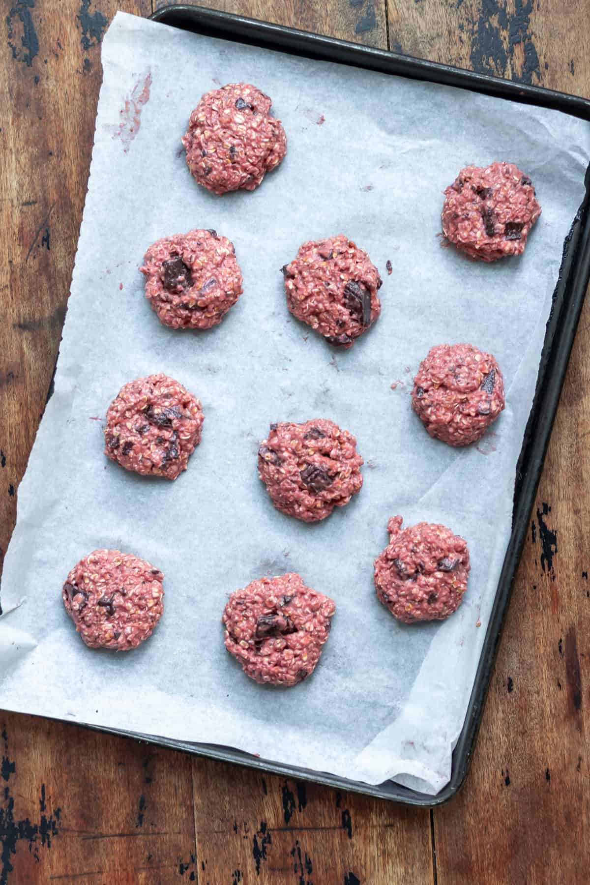 Scoops of cookie batter on a baking sheet.