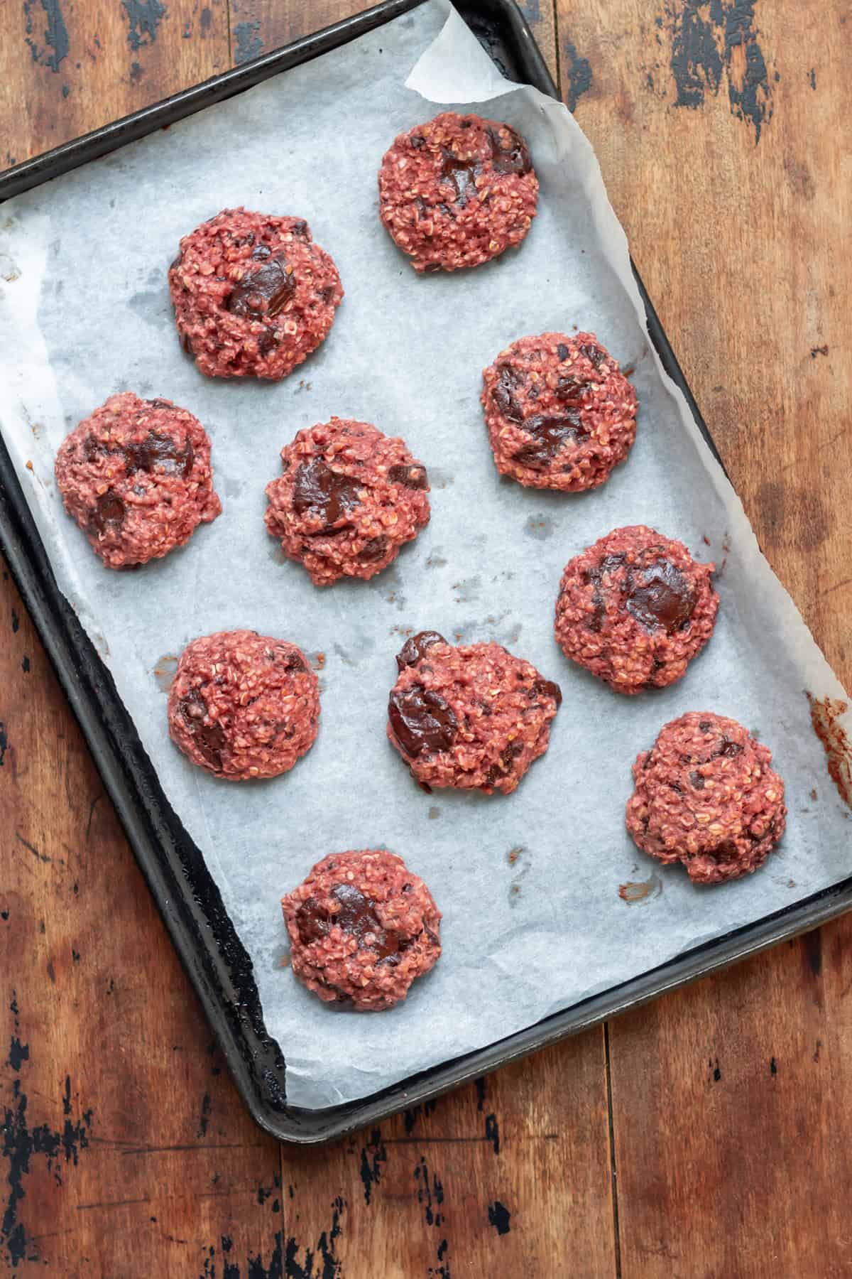 Baked chocolate chunk beetroot cookies on a baking sheet.