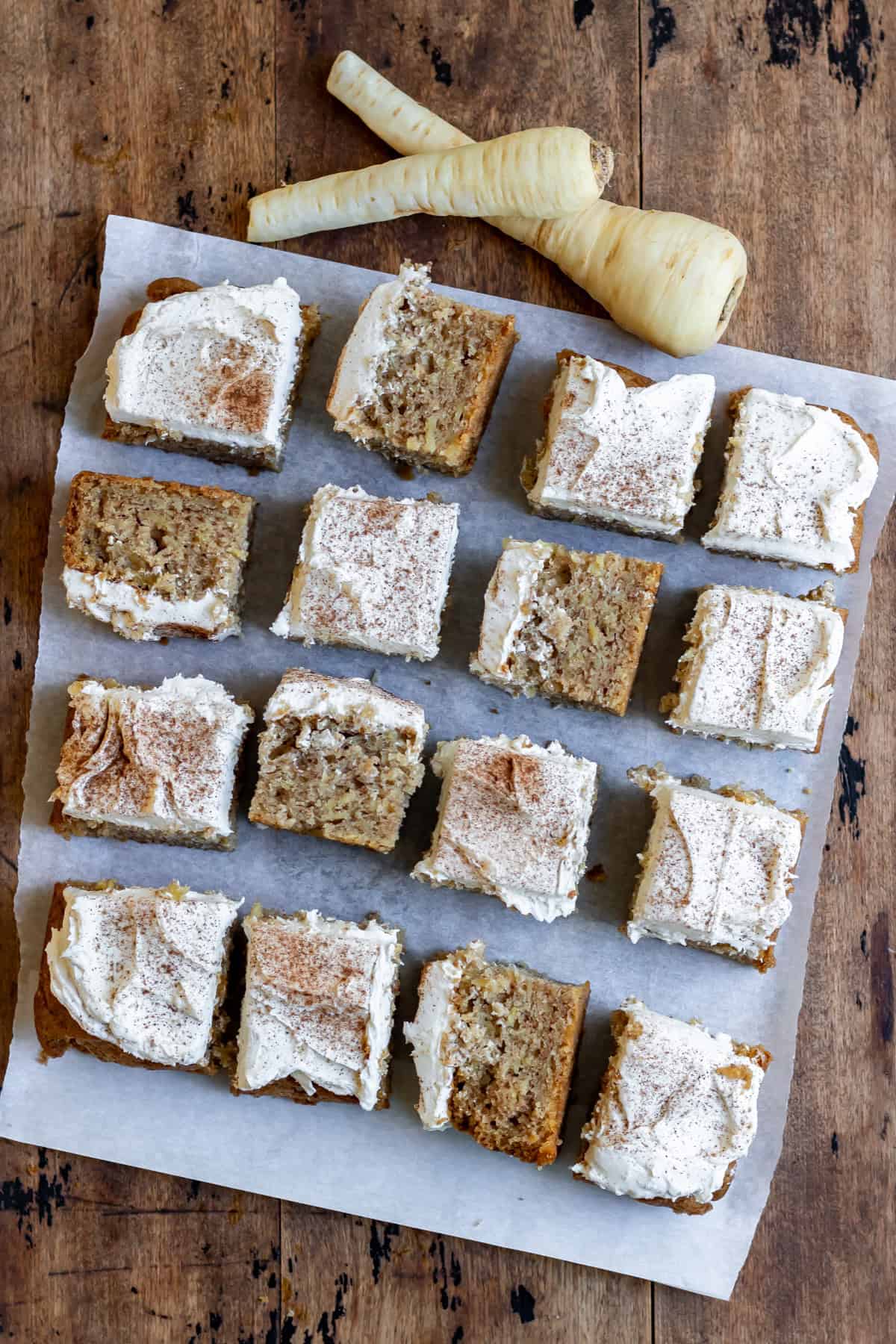 Cut parsnip cake with nutmeg buttercream, with some squares turned on their side.