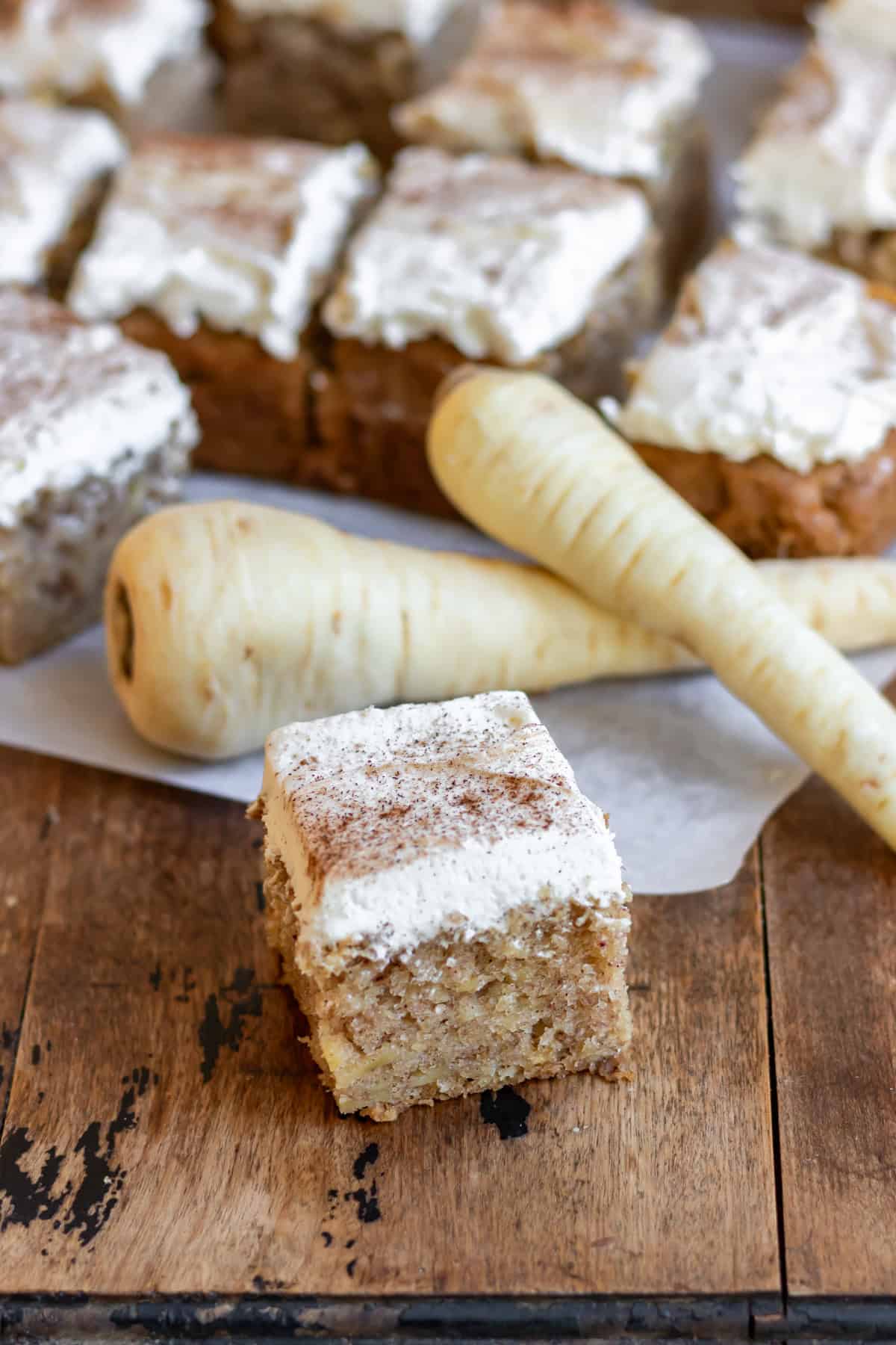 A wooden table with squares of parsnip tray cake.