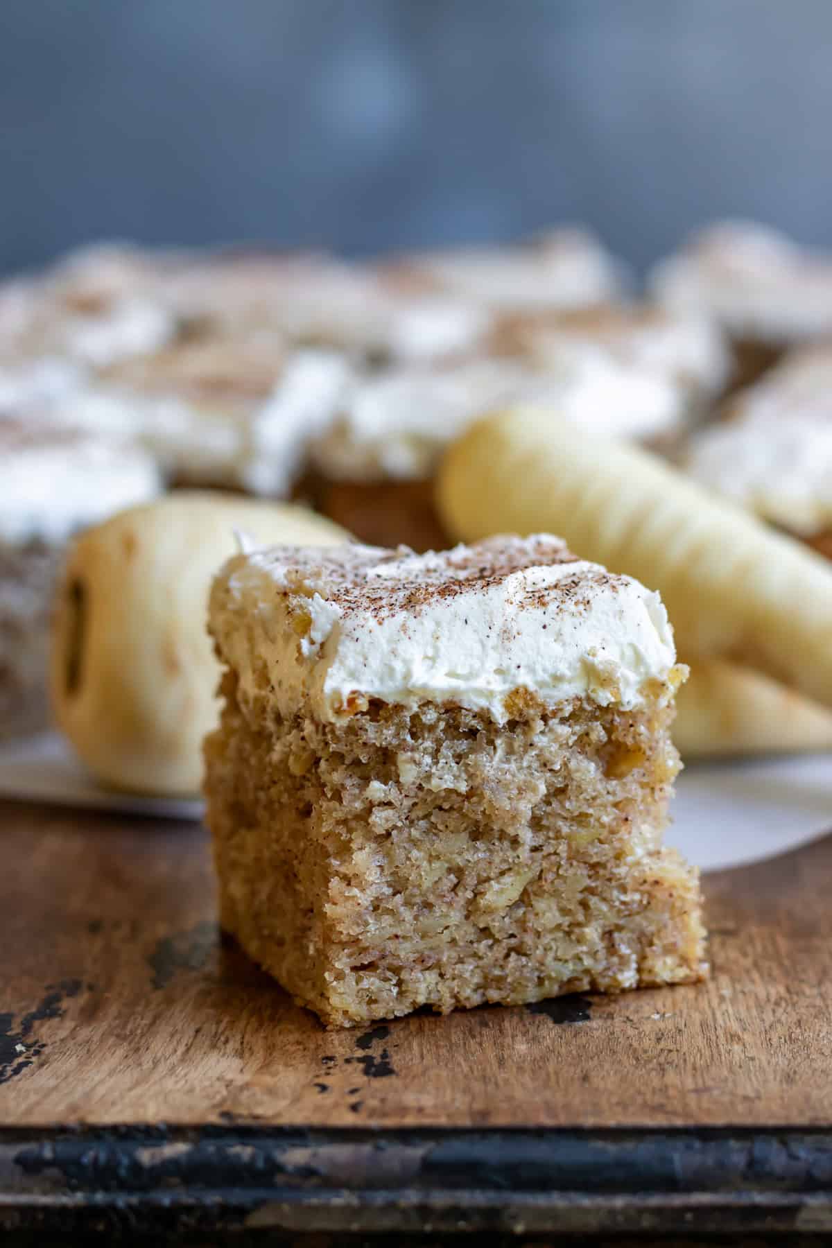 Side view of a slice of parsnip cake with nutmeg frosting.