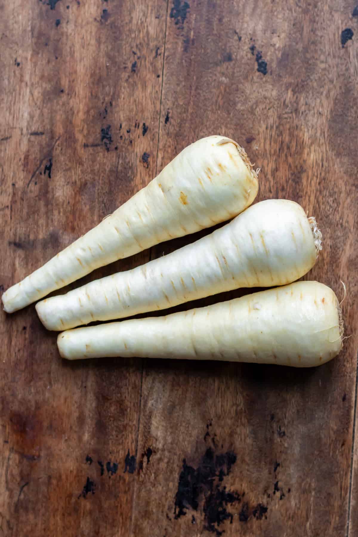 Three parsnips on a table.