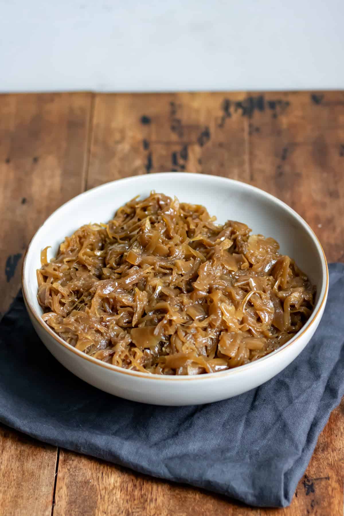 A dish of caramelised onions on a wooden table.