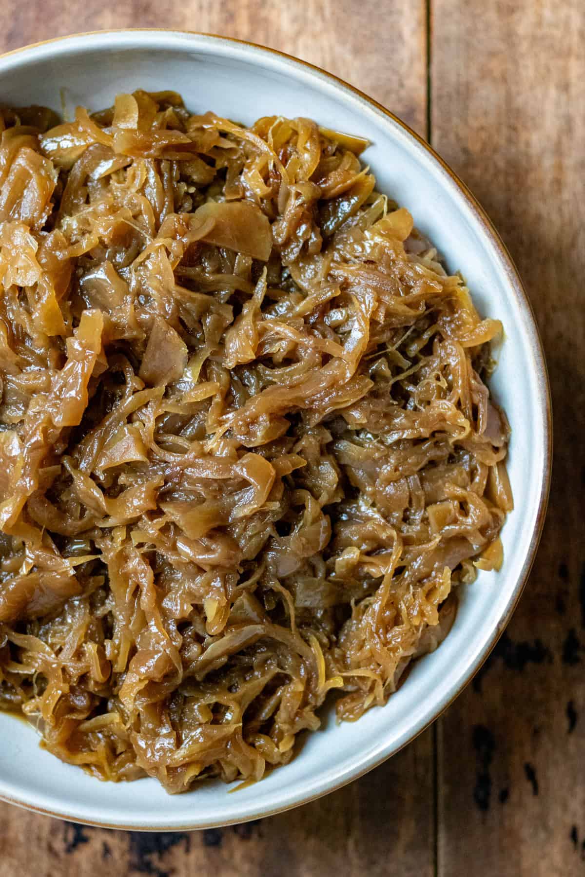 Looking down at a bowl of slow cooker caramelised onions.