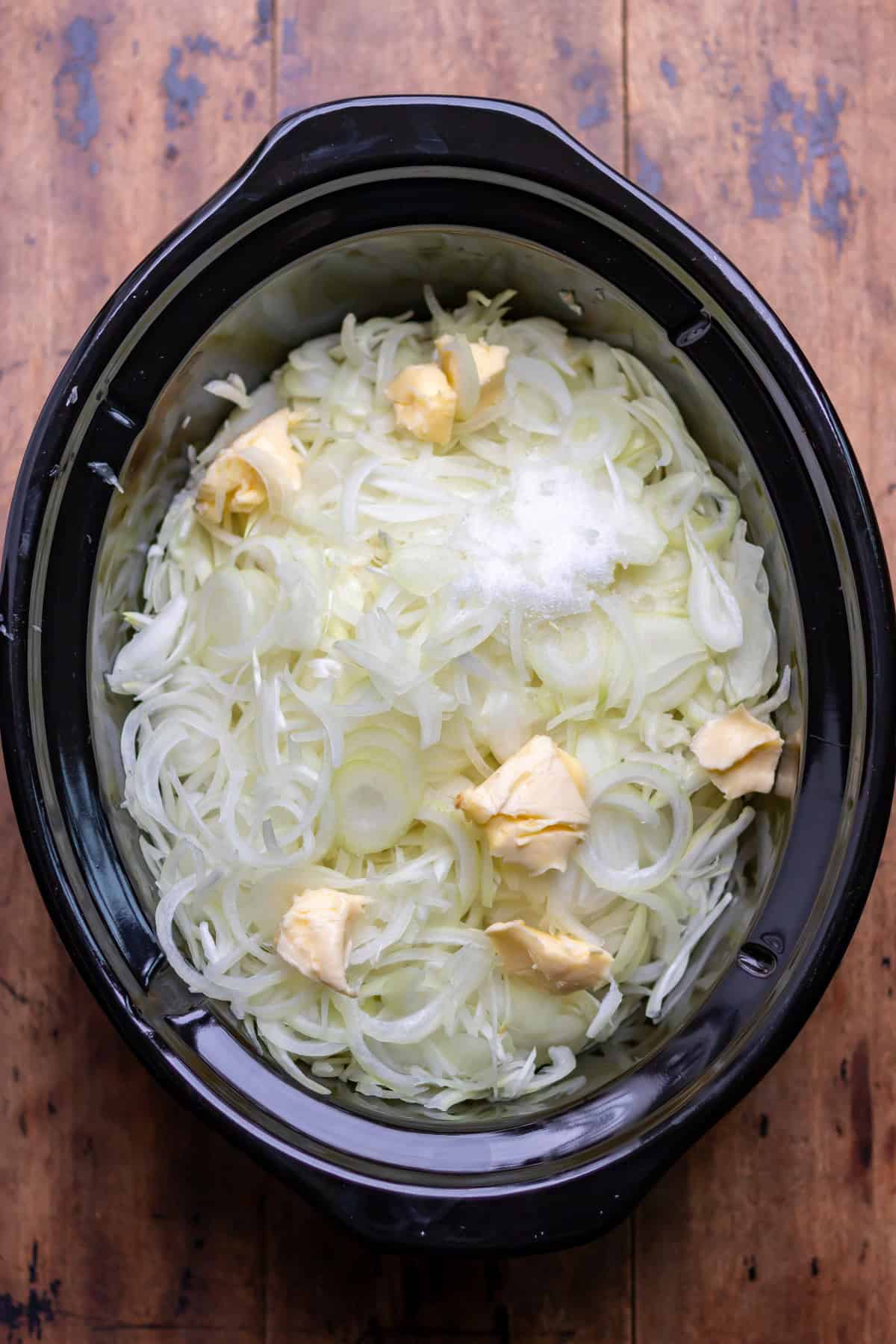 Butter and sugar added to the onions in the slow cooker.