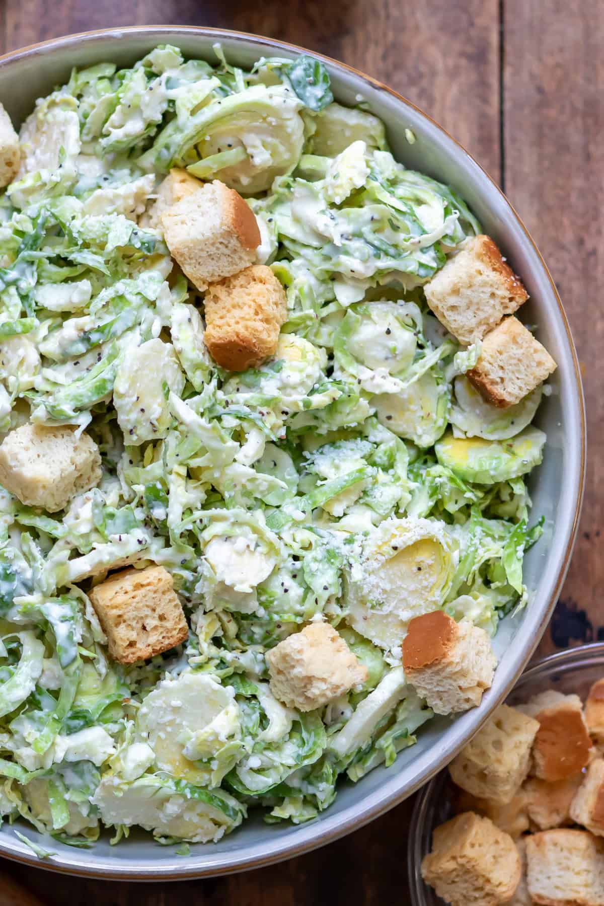 Looking down at a serving dish of brussels sprouts caesar slaw.
