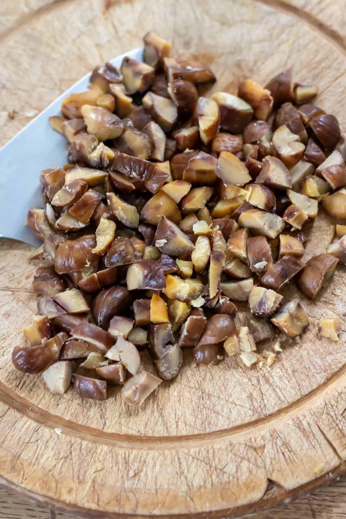Chopping chestnuts on a wooden cutting board.