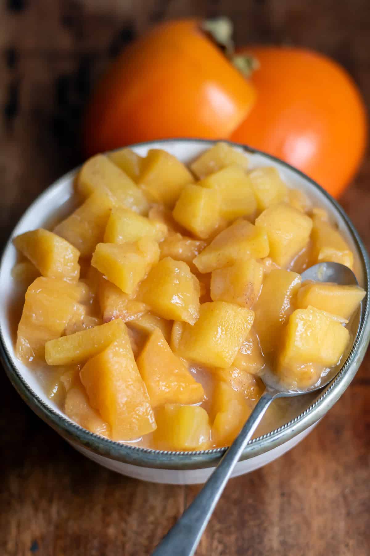 Spoon in a small bowl of persimmon compote.