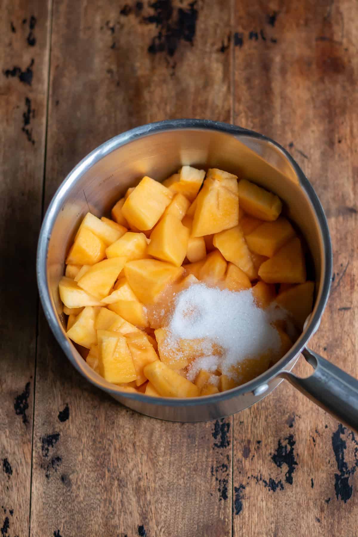 Chopped persimmons, water and sugar in a small pot.