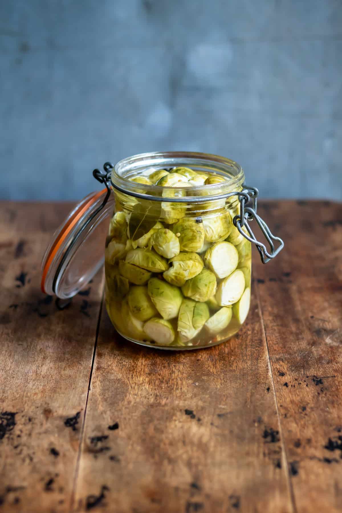 Side view of a jar of quick pickled brussels sprouts.