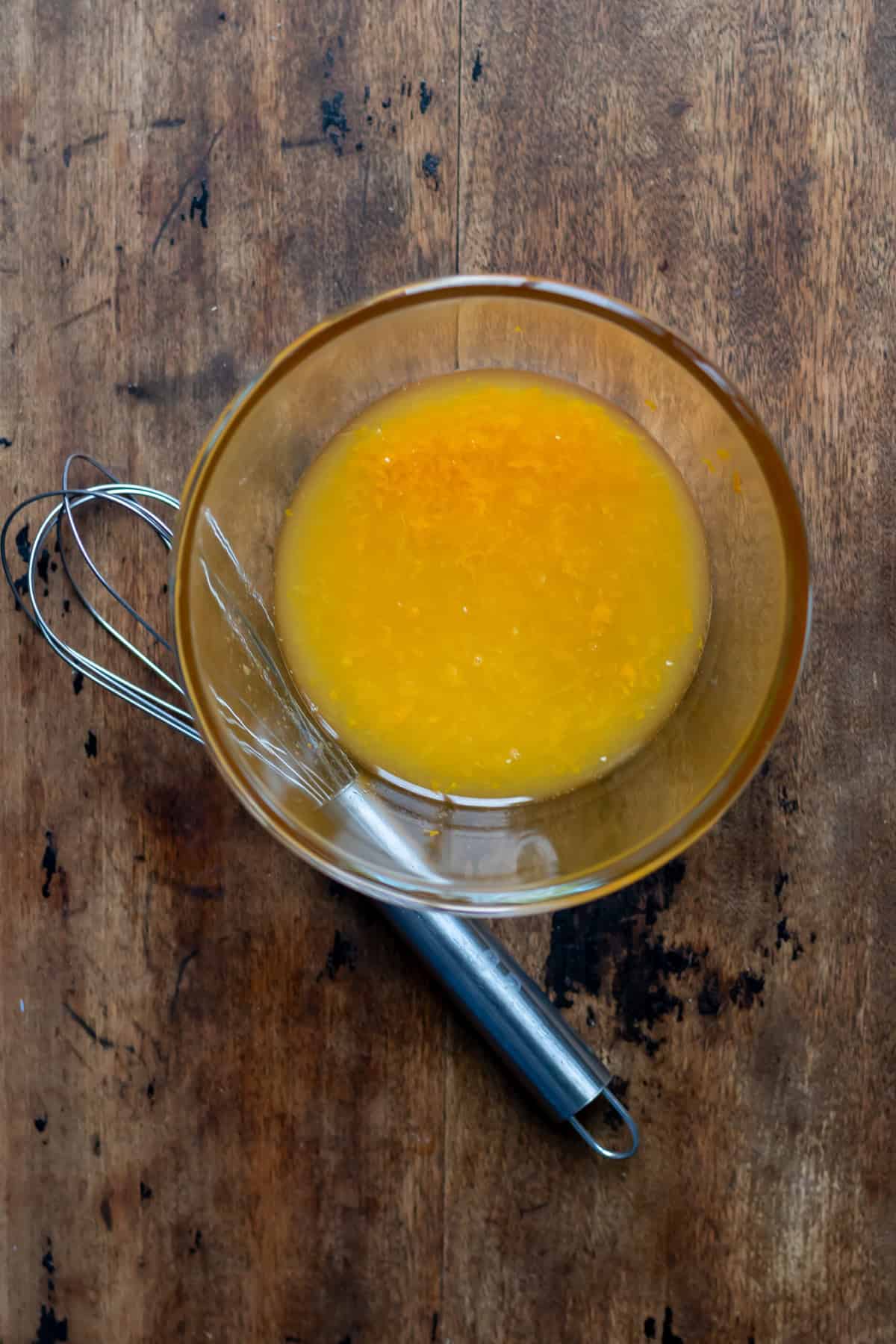 Orange, zest and honey mixed in a bowl.
