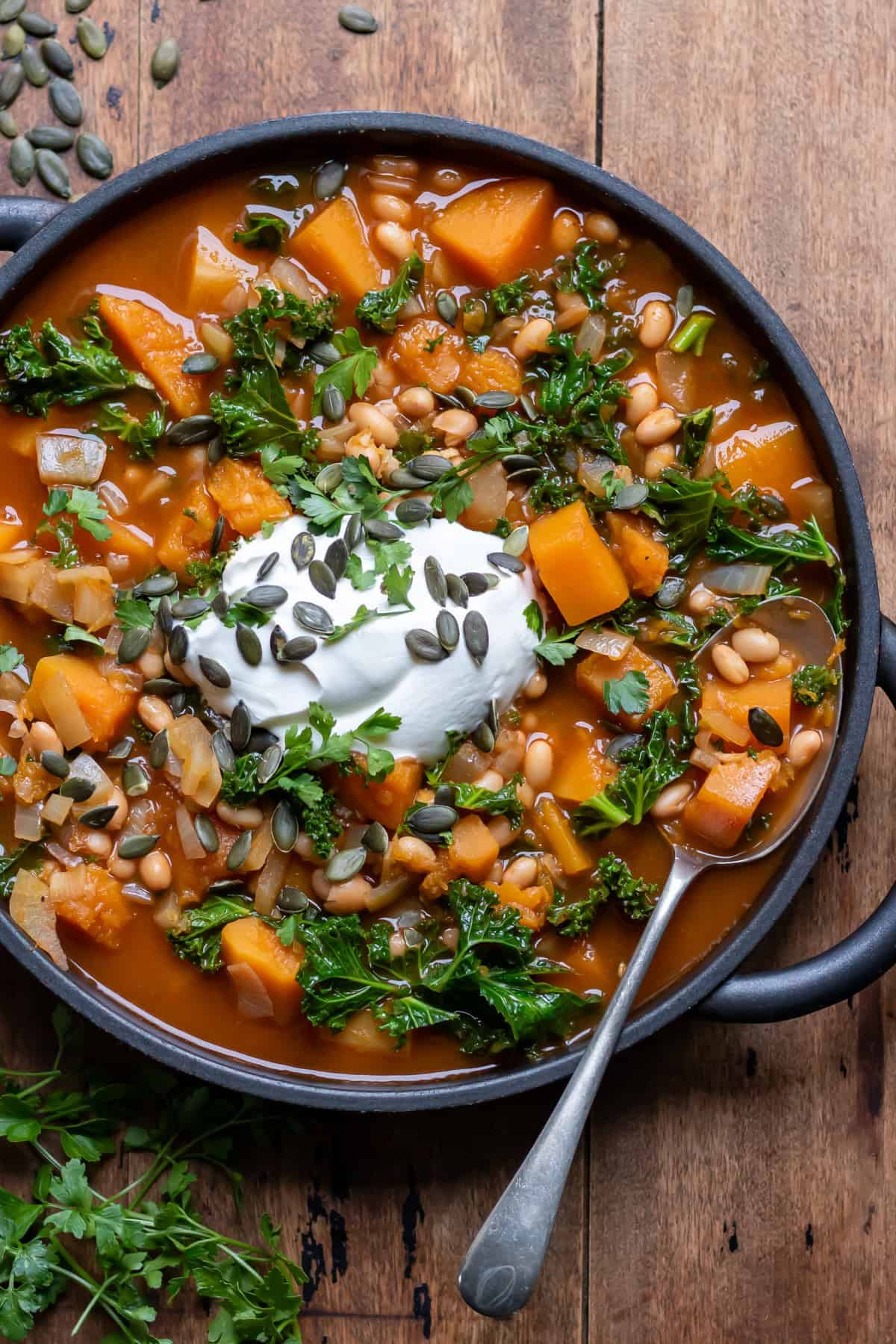 Serving spoon in a dish of squash and bean soup.