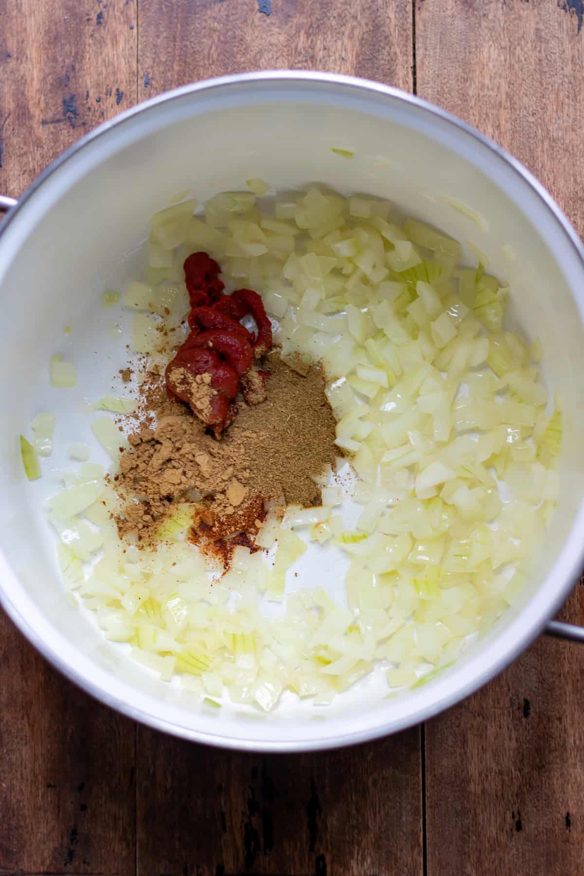 Softened onions in a pot along with the spices and tomato paste.