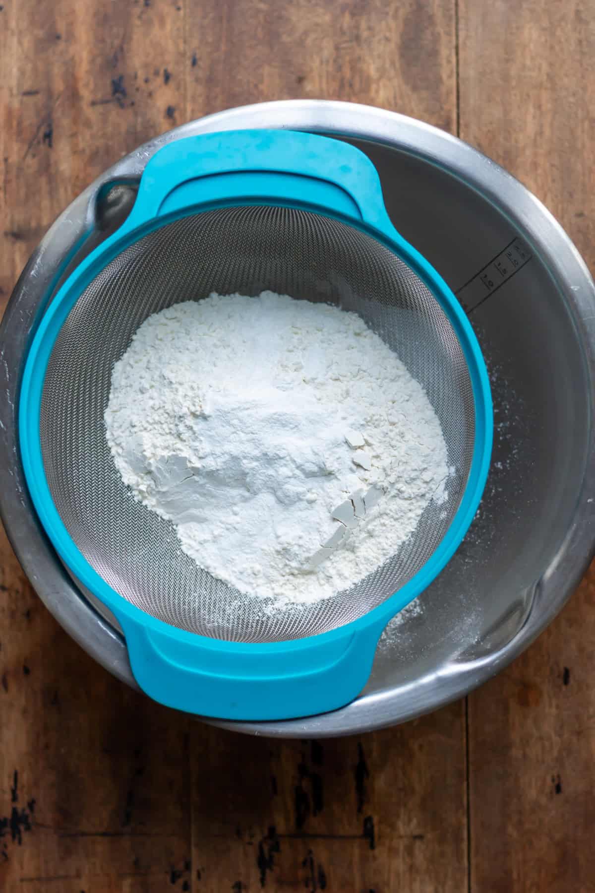 Sifting the dry ingredients into a mixing bowl.