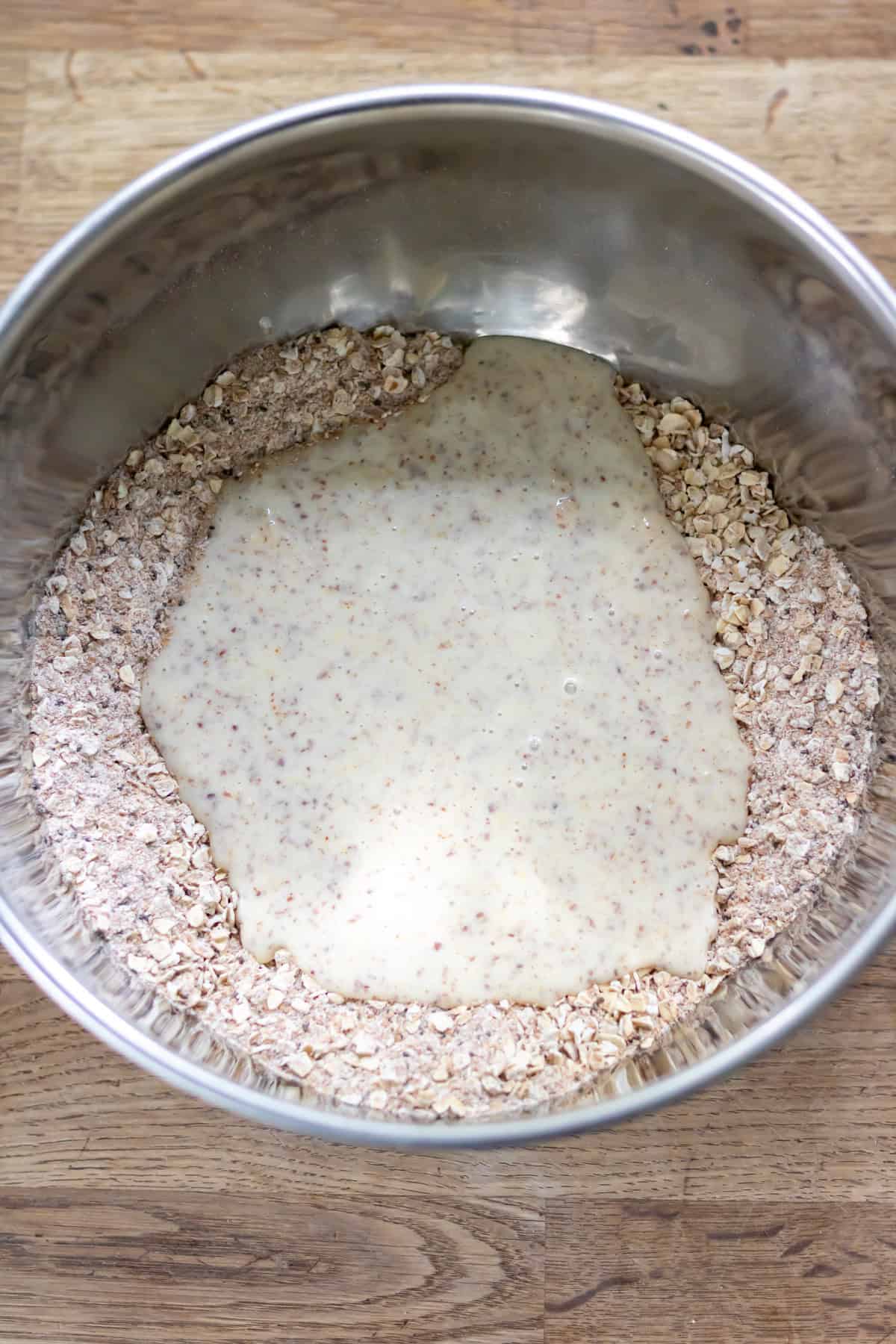 Wet ingredients added to dry ingredients in a mixing bowl.