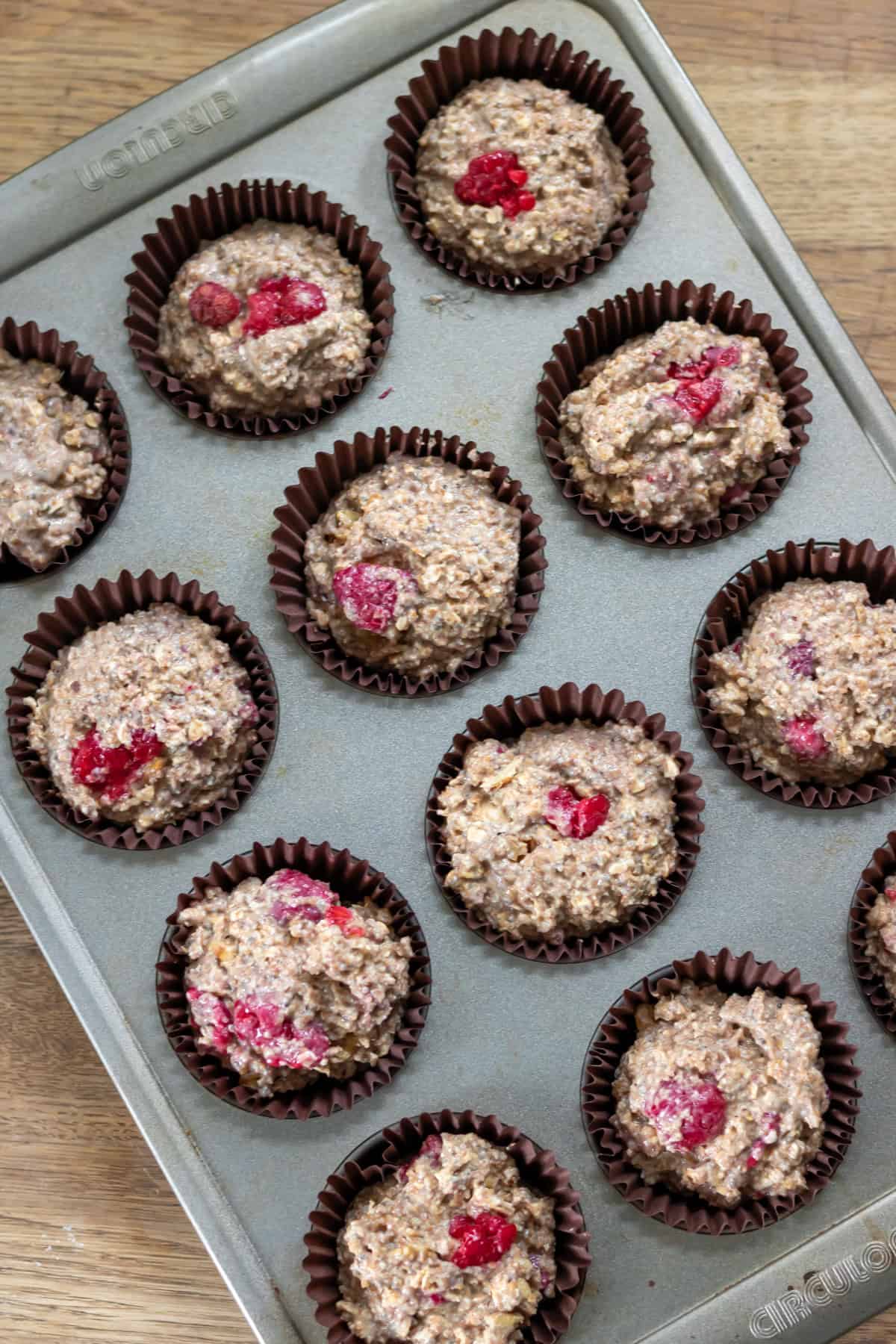 Muffin batter in muffin tray waiting to be baked.